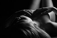 Photo sensuelle en noir et blanc d'une femme nue sur le dos