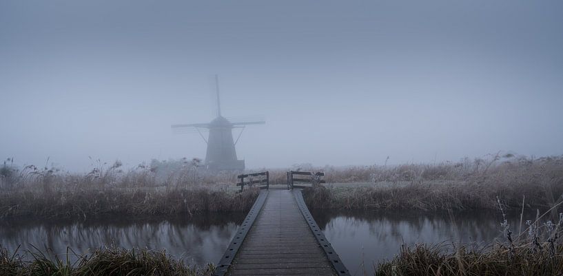 Windmühle in Kinderdijk in den Nebel von Toon van den Einde