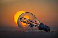 Glühbirne am Strand im Angesicht der untergehenden Sonne.