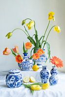 Uitbundig stilleven met tulp,citroen, gerbera in  delfts blauwe vaasjes lichte achtergrond