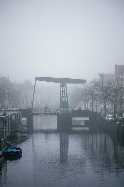 Cycliste sur un pont dans le brouillard - photographie de rue atmosphérique par Studio Ajuut