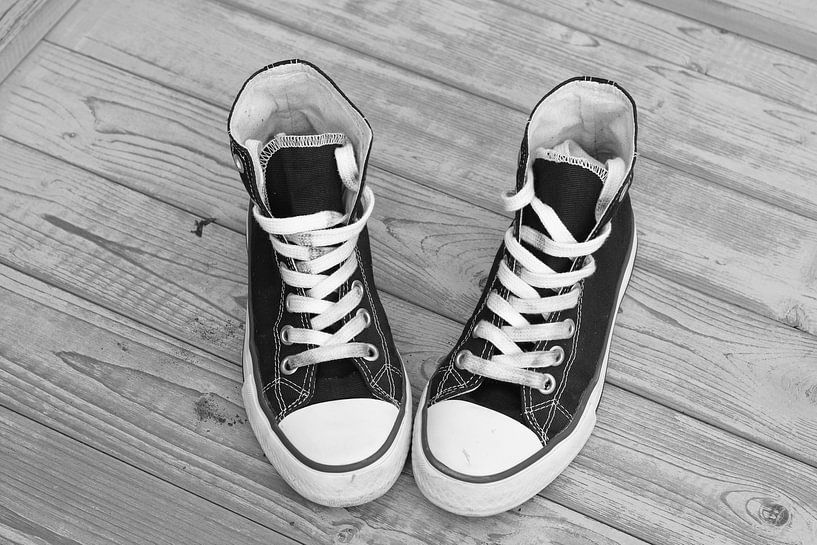 Canvas sneaker shoes on vintage wooden background by Trinet Uzun