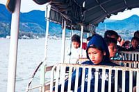 Indonesische schooljongen op de veerpont kijkt nadenkend in de verte