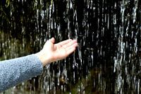 Main dans la chute d'eau