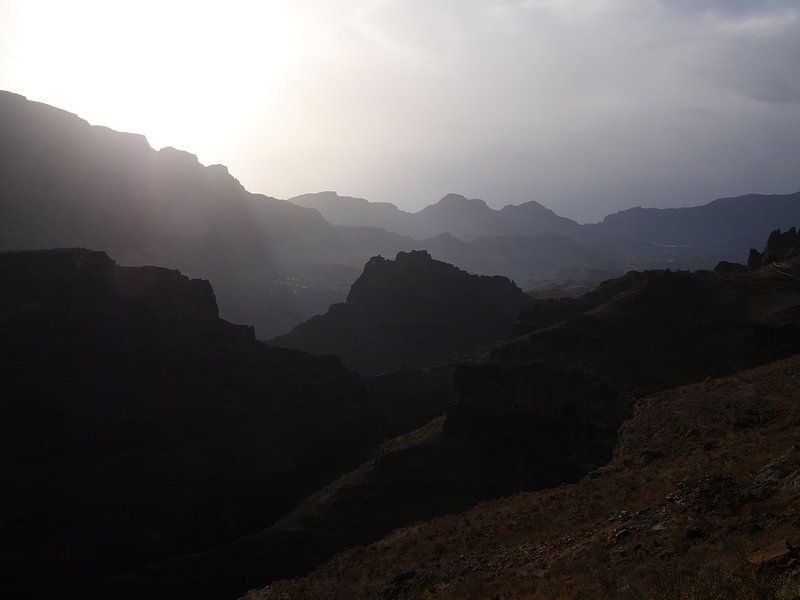 Berge im dunklen Schatten mit Sonne im Rücken von Judith van Wijk