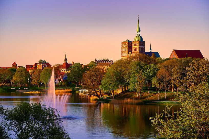 Silhouette of the Hanseatic city of Stralsund in the evening light with fountain and pond by Stefan Dinse