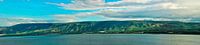 Golan Heights and Tiberian Lake panorama where green hills, blue sky with clouds and the surface of 