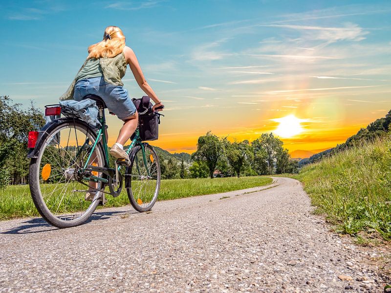 young woman with the bicycle on the Danube cycle track by Animaflora PicsStock