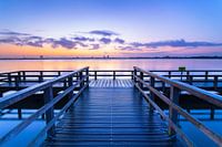 Une jetée sur un lac lors d'un lever de soleil