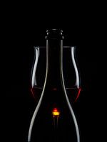 A bottle, a glass, red wine.