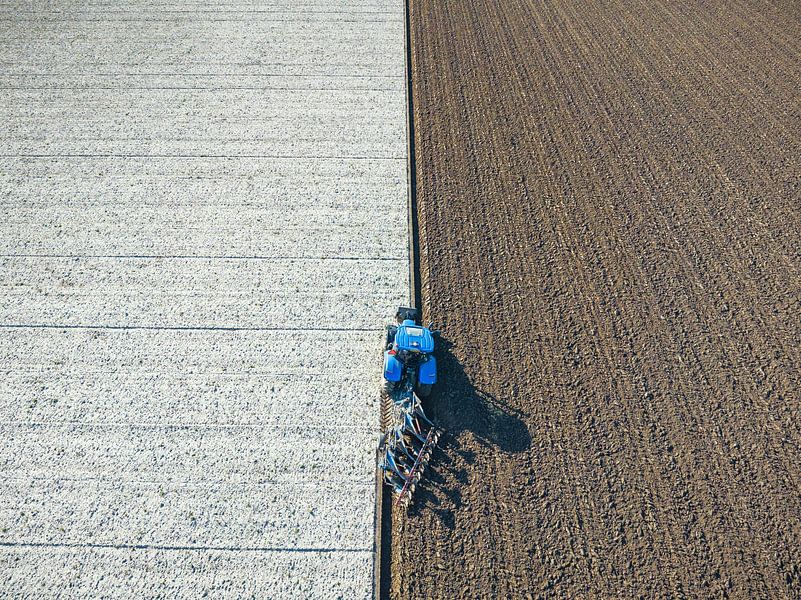 Tractor ploegt de grond voor het planten van gewassen  van Sjoerd van der Wal Fotografie