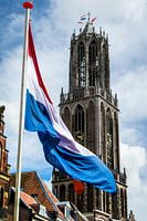 Nederlandse vlag wappert voor de Utrechtse Domtoren op Koningsdag.