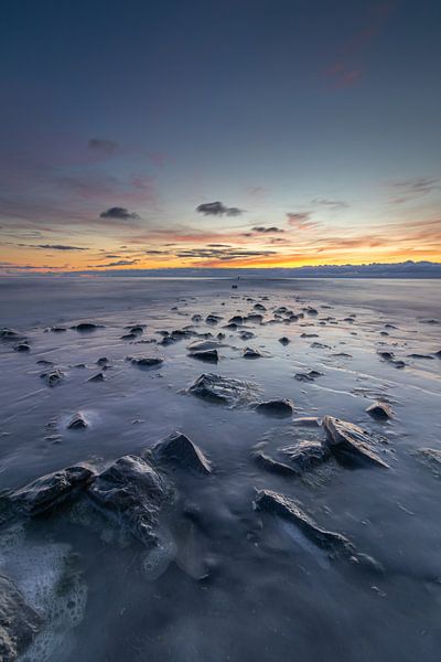 La jetée émerge lentement tandis que la mer se retire de la vue lors d'un coucher de soleil coloré. par Bram Lubbers