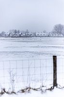 A Dutch village in the snow behind a fence