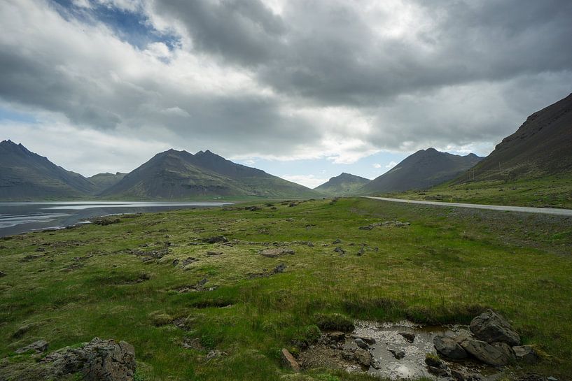 Island - Endlose Straße durch dunkle Berge und grüne Landschaft von adventure-photos