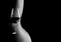 Photo artistique de femme nue avec un verre de vin dans le dos