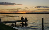 Coucher de soleil avec des gens sur la jetée des lacs de Loosdrecht