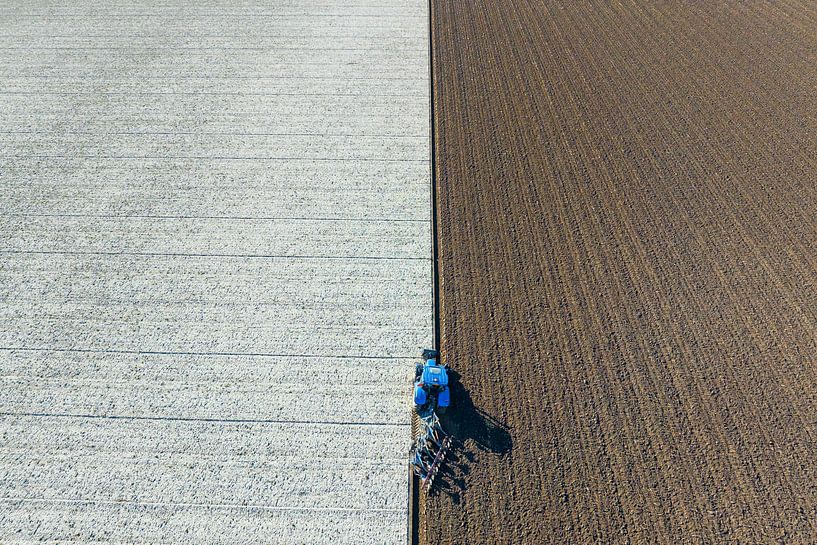 Tractor ploughing the soil for planting crops seen from above by Sjoerd van der Wal Photography
