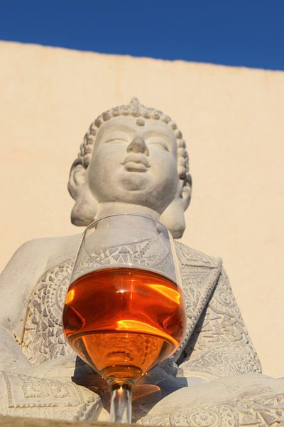 Bouddha avec un verre de vin contre un mur et un ciel bleu vif par Studio LE-gals