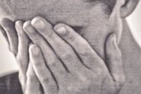 La tête dans les mains.