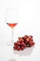 Modernes Stilleben mit einem Glas Wein und Weintrauben