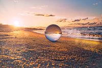 Sphère de verre sur la plage de Zingst, au coucher du soleil. Le soleil et la mer Baltique se reflèt