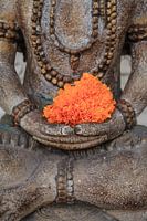 Lovely Buddha with orange flower somewere in Ubud.