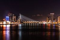 Rotterdam by Night - Erasmus Bridge and skylineIn this photo, you can see the Erasmus Bridge in all its glory, tightly lit against Rotterdam's skyline. The lights of the city reflect on the water of the river Maas, giving the picture a lively look. To the left you see the modern high-rise buildings, to the right the striking De Rotterdam building. Everything together forms a recognisable and powerful cityscape.