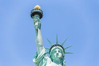 Vue rapprochée de la Statue de la Liberté sur un ciel bleu