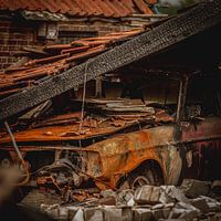 Burned volvo under collapsed barn roof