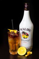 Cocktail acidulé Disaronno avec du citron comme garniture et un fond noir