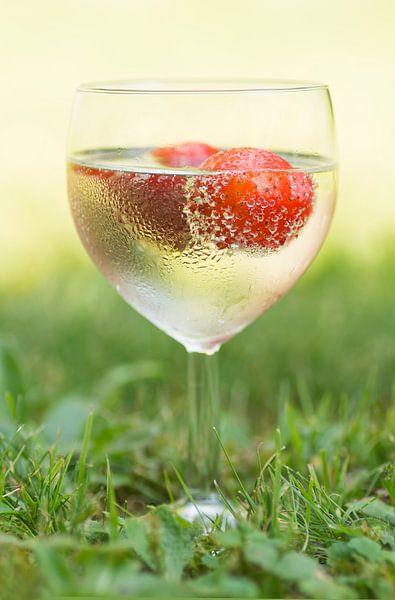 A glass full of summer (cocktail of wine and a strawberry in glass with drops) by Birgitte Bergman