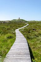 Wooden path to the lighthouse under a clear sky