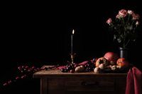 Vie silencieuse avec bougie, fruits, noix et roses