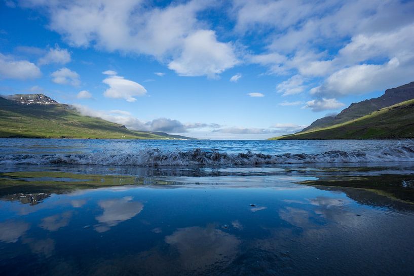 Island - Spiegelnder Himmel und Wolken am einsamen schwarzen Sandstrand von adventure-photos