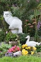 Katze spielt für Gartenstatue