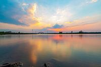 Buntes Abendlicht, das sich im Wasser spiegelt und nach Sonnenuntergang leuchtet.