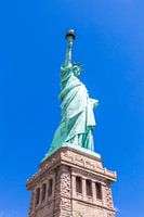 Vue rapprochée de la Statue de la Liberté sur un ciel bleu