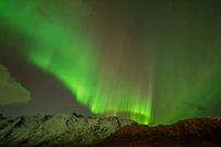Aurore boréale sur des montagnes enneigées