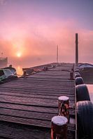 A misty sunrise by the water with beautiful colors in the sky