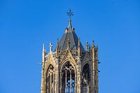 Die gotische Turmspitze der Kathedrale vor blauem Himmel.