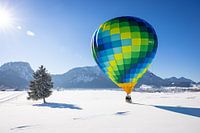 Hot air balloons adorn the sky over a snowy Inzell in Germany