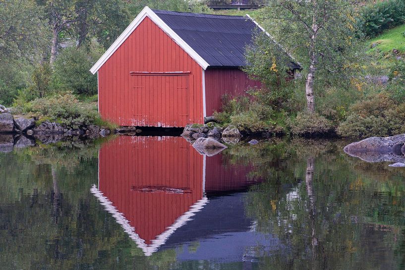 Mirrored wooden boathouse on the lake in Norway by Henk Alblas