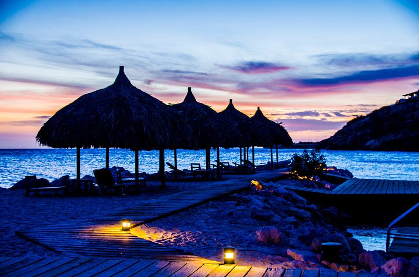Palapas bei farbenfrohem Sonnenuntergang von Joke Van Eeghem
