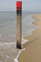 Strandpaal in opkomend water