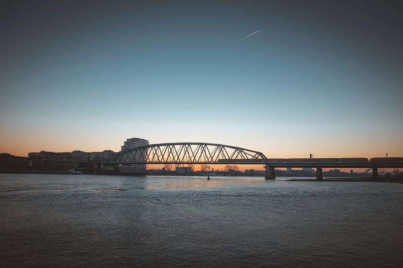 Train on Snelbinder at Nijmegen at sunset by Youri Zwart