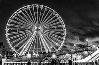 The illuminated Ferris wheel has a magisterial look against the black sky