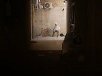 Italienische Seniorin mit Kaktus sitzt im Morgenlicht