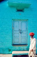 Un Indien passe devant une maison.