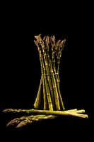 Verse groene asperges met een zwarte achtregrond
